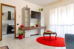 a living room with a table and a red rug at Fiori del Lario 110 Mq #Fiera Rho Milano Como Malpensa in Cesate