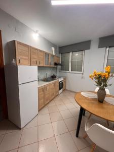 a kitchen with a white refrigerator and a table at Ήρεμο σπίτι casa puente in Stenón