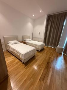 two beds in a room with a wooden floor at Luxury Villa Silente in Mjull-Bethore