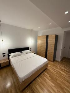 a bedroom with a large white bed and wooden floors at Luxury Villa Silente in Mjull-Bethore +68 photos