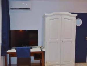 a room with a desk and a tv and a white door at Brise Marine in Le Marin +2 photos