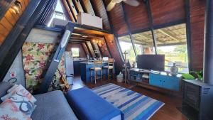 a living room with a couch and a kitchen in a house at Wiri House na beira da Lagoa Doce in Imbituba