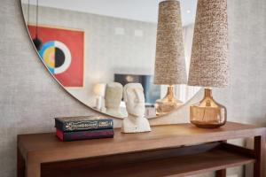 einen Tisch mit zwei Lampen und einem Spiegel in der Unterkunft Luxury Apartment Tamana Burgundy - by Welcomely in Jávea