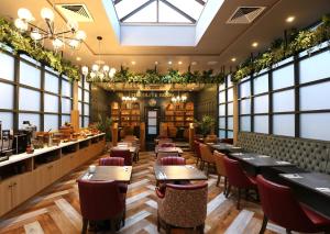 a restaurant with tables and chairs and windows at The Maiden City Hotel in Derry Londonderry