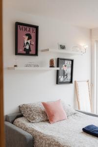 a bedroom with a couch and a shelf on the wall at Le 112 Deauville - Plage & Casino in Deauville