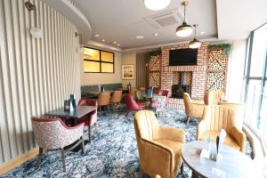 a hotel lobby with tables and chairs and a fireplace at The Maiden City Hotel in Derry Londonderry