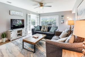 a living room with a couch and a tv at Palm Coast Escape with Outdoor Oasis 6 Mi to Shore! in Palm Coast