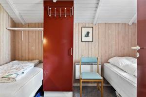 a room with two beds and a chair in it at 0300-Romo-Vestergade-3-Ap-73 in Havneby