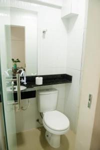 a white bathroom with a toilet and a sink at Loft centro de Manaus 708 in Manaus +26 photos