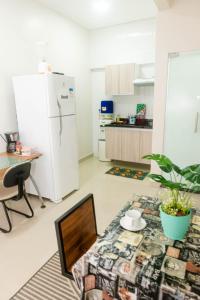 a kitchen with a refrigerator and a table with a laptop at Loft centro de Manaus 708 in Manaus