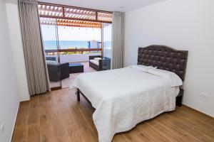 a bedroom with a bed and a view of the ocean at Condominio Villa Rose in Zorritos