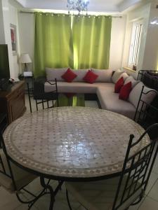 a living room with a table and a couch at Appartement OCEAN VIEW in Tamraght Ouzdar