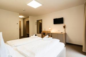 Un dormitorio con dos camas y un televisor en la pared. en Hotel Stubnerhof, en Bad Gastein