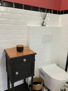 a bathroom with a toilet and a table with a sink at Le pigeonnier in Nîmes