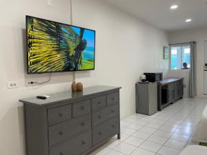 uma sala de estar com uma TV na parede em The Irie Inn em Montego Bay