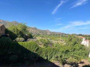 a view of a garden with mountains in the background at Gattopardo's Taormina big house in Taormina