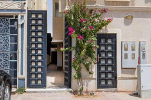 リヤドにあるNuzul R179 - Elegant Studioの建物の上にピンクの花が飾られた開いたドア