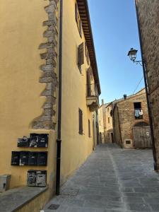 an alley with a building with a stone wall at La Casina di Pinutte in Campagnatico