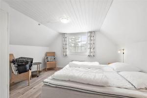 a white bedroom with a large bed and a window at 0194-Romo-Rabjergvej-76 in Kongsmark