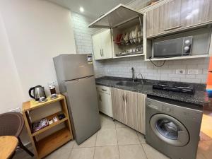 a kitchen with a refrigerator and a washing machine at Golf porto marina pool view in El Alamein