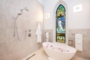a bathroom with a bath tub and a stained glass window at The Mastic Chapel Cottage in North Side