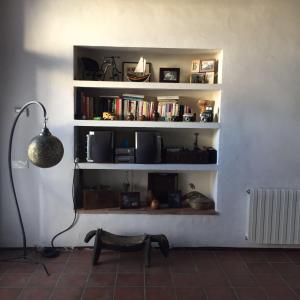 a room with a book shelf with books and a lamp at El Terral in Sant Vicenç de Montalt