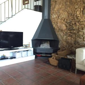 a living room with a fireplace and a tv at El Terral in Sant Vicenç de Montalt +55 photos
