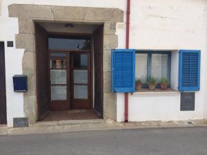 a door and window with blue shutters on a building at El Terral in Sant Vicenç de Montalt