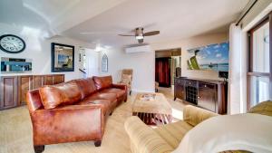 a living room with a leather couch and a clock at Seven Mile View Condo #2 in West Bay +57 photos