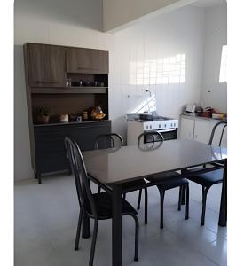 a kitchen with a table and chairs and a stove at Unidade 2 in Bauru