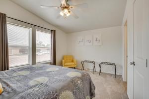 a bedroom with a bed with a ceiling fan and a window at 1 Mi to Main Street Cozy Retreat in Portales in Portales