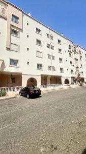 a black car parked in front of a large building at High Altitude Makkah - Aziziya Spacious Flat in Makkah
