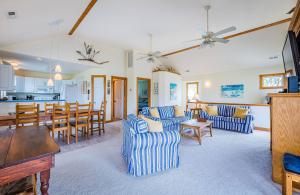 Una sala de estar con muebles azules y blancos y una cocina. en Duck Haven D3001 - Pool & Hot Tub, Easy Walk to Ocean & Sound, en Duck
