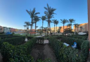 a view of a park with palm trees and buildings at Golf porto marina pool view in El Alamein