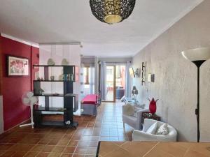 een woonkamer met rode muren en een bank en stoel bij Apartamentos Magdalena in Valle Gran Rey