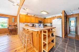 a kitchen with wooden cabinets and a white refrigerator at Duck Redux - Ocean Dunes, Oceanside, 350 Yds to Beach, One Level, Pets OK, Walk to Downtown in Duck