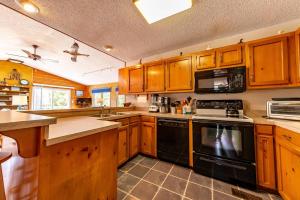 a kitchen with wooden cabinets and black appliances at Duck Redux - Ocean Dunes, Oceanside, 350 Yds to Beach, One Level, Pets OK, Walk to Downtown in Duck