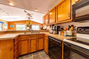 a kitchen with wooden cabinets and a sink at Duck Redux - Ocean Dunes, Oceanside, 350 Yds to Beach, One Level, Pets OK, Walk to Downtown in Duck