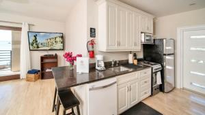 a kitchen with white cabinets and a black refrigerator at Seven Mile View Condo #3B in West Bay