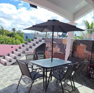 a table and chairs with an umbrella on a patio at villa atomium in Midlands Station
