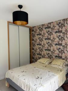 ein Schlafzimmer mit einem großen Bett mit geblümter Tapete in der Unterkunft La maison près de la fontaine B&B paisible 1 in Lépanges-sur-Vologne