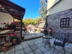 a patio with tables and chairs and a building at Penzion Nad Kašnou in Kašperské Hory