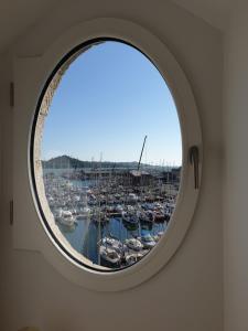 a round window with a view of a harbor at Loft d'architecte - vue sur port et deco vintage in Paimpol