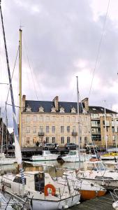 a group of boats docked in a harbor with a building at Loft d'architecte - vue sur port et deco vintage in Paimpol