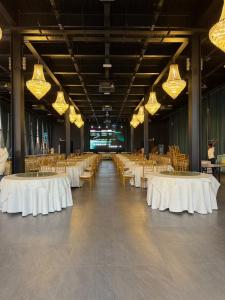 a large banquet hall with white tables and chairs at MI LE GARDEN Chalet in Sekinchan