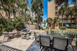 a patio with a grill and tables and chairs at 2 Bedroom Beachside Suite in Clearwater Beach
