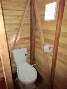 a bathroom with a toilet and a roll of toilet paper at Manglar Eco Resort in La Barra +13 photos