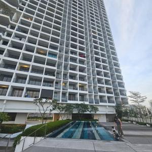 a large building with a swimming pool in front of it at Black Martini Premium Suite in Tanjong Tokong +9 photos