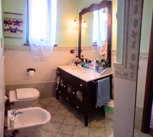 a bathroom with a sink and a toilet and a mirror at Cozy Valeria's Room in Camaiore