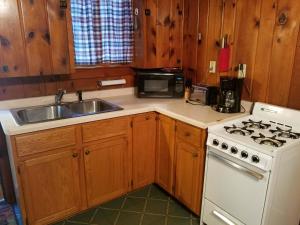 a kitchen with a stove and a sink and a microwave at Old Stoney's Musky - Big Arbor Vitae Lake in Arbor Vitae